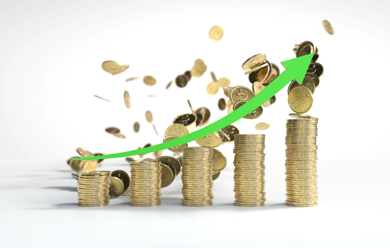 Una flecha verde curva ascendente sobre pilas de monedas doradas ordenadas en forma de gráfico de barras creciente.